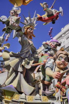 Spain, Valencia Province, Valencia, Papier Mache figure of a woman resembling the Statue of Liberty with various other figures flying around her during Las Fallas festival.