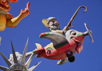 Spain, Valencia Province, Valencia, Papier Mache figure flying an airplane resembling a fish during Las Fallas festival.