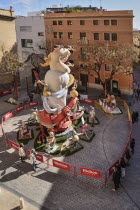 Spain, Valencia Province, Valencia, Papier Mache falla scene with onlookers viewing a giant figure of a lady  in the street at Torres de Quart during Las Fallas festival.