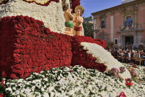 Spain, Valencia Province, Valencia, Base of the Statue of Virgen de los Desamparados, Our Lady of the Forsaken, decked out with flowers carried in the religious procession during Las Fallas festival.