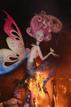 Spain, Valencia Province, Valencia, La Crema, The Burning of the Papier Mache figures in the street during Las Fallas festival on March 19th, fairy figure going up in flames.