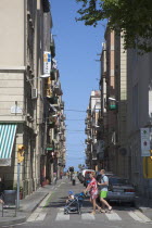 Spain, Catalonia, Barcelona, Barceloneta, View across Passeig de Joan de Borbo with tourists crossing the road.