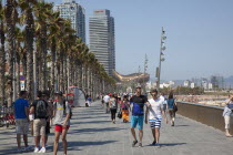 Spain, Catalonia, Barcelona, Barceloneta, Playa de St Sebastia, people walking along the promenade.