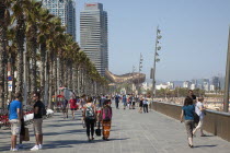 Spain, Catalonia, Barcelona, Barceloneta, Playa de St Sebastia, people walking along the promenade.