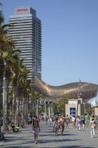 Spain, Catalonia, Barcelona, Barceloneta, Playa de St Sebastia, people walking along the promenade.