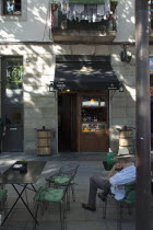 Spain, Catalonia, Barcelona, Rambla del Raval, Man wearing hat sat at table outside the Catalan Suculent restaurant.