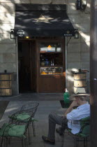 Spain, Catalonia, Barcelona, Rambla del Raval, Man wearing hat sat at table outside the Catalan Suculent restaurant.