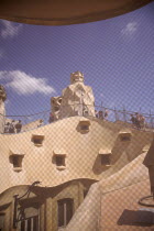 Spain, Catalonia, Barcelona, La Pedrera or Casa Mila on Passeig de Gracia, designed by Antoni Gaudi, view of the roof through mesh covered attic window.