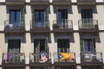 Spain, Catalonia, Barcelona, Eixample, Typical apartment building facade with balconis, flying Catalan independence flags.