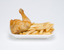 Food, Cooked, Poultry, fried chicken quarter and potato chips in an insulated polystyrene foam tray on a white background.