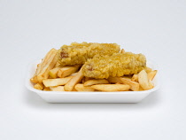 Food, Cooked, Meat, Two battered pork sausage with potato chips in an insulated polystyrene foam tray on a white background.