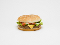 Food, Cooked, Meat, Single cheesburger with salad and tomato ketchup in a bun on a white background.