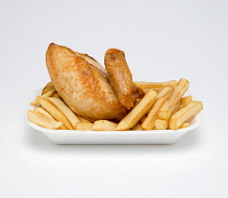 Food, Cooked, Poultry, Fried chicken quarter with potato chips in a polystyrene foam tray on a white background.