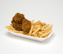 Food, Cooked, Poultry, Battered chicken wings with potato chips in a polystyrene foam tray on a white background.