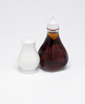 Food, Condiment, Vinegar, A bottle of malt vinegar beside a white salt-cellar on a white background.