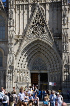 Spain, Catalonia, Barcelona, People on the steps below the main facade of the Gothic Cathedral in the Old Town district.