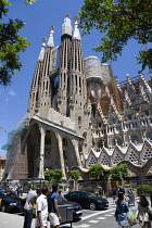 Spain, catalonia, Barcelona, Tourists viewing the basilica church of Sagrada Familia deisigned by Antoni Gaudi in the Eixample district.