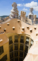 Spain, Catalonia, Barcelona, Tourist visitors on the roof of Casa Mila apartment building known as La Pedrera or Stone Quarry designed by Antoni Gaudi in the Eixample district.