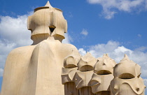 Spain, Catalonia, Barcelona, Chimneys and vents on the roof of Casa Mila apartment building known as La Pedrera or Stone Quarry designed by Antoni Gaudi in the Eixample district.