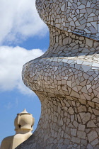 Spain, Catalonia, Barcelona, Chimneys and vents on the roof of Casa Mila apartment building known as La Pedrera or Stone Quarry designed by Antoni Gaudi in the Eixample district.