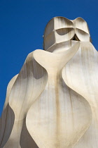 Spain, Catalonia, Barcelona, Chimneys and vents on the roof of Casa Mila apartment building known as La Pedrera or Stone Quarry designed by Antoni Gaudi in the Eixample district.