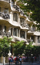 Spain, catalonia, Barcelona, Visitors in a queue outside Casa Mila apartment building known as La Pedrera or Stone Quarry designed by Antoni Gaudi in the Eixample district.