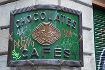 Spain, Catalonia, Barcelona, Fargas Chocolates Cafes sign with graffiti on it in the Gothic Quarter.