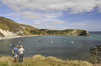England, Dorset, Isle of Purbeck, Couple looking out over Lulworth Cove and  Jurassic Coast.