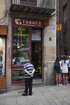 Spain, Catalonia, Barcelona, Tour guide and tourists in the narrow streets of the Gothic Quarter.