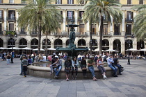 Spain, Catalonia, Barcelona, Tourists sat around the fountain in Placa Reial.