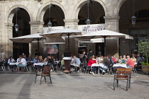 Spain, Catalonia, Barcelona, Tourists sat at tables outside cafe in Placa Reial.