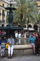 Spain, Catalonia, Barcelona, Tourists sat around the fountain in Placa Reial.