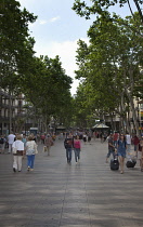 Spain, Catalonia, Barcelona, Tourist walking along the tree lined avenue of La Rambla.