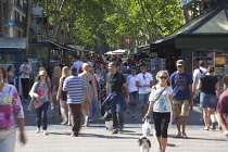 Spain, Catalonia, Barcelona, Tourist walking along the tree lined avenue of La Rambla.