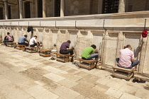 Turkey, Istanbul, Men washing their feet in preparation for prayers, at Suleymaniye Mosque.