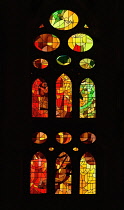 Spain, Catalunya, Barcelona, Basilica i Temple Expiatori de la Sagrada Familia, Colourful stained glass window details on the Passion Facade wing.