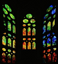 Spain, Catalunya, Barcelona, Basilica i Temple Expiatori de la Sagrada Familia, Colourful stained glass window details on the Passion Facade wing.