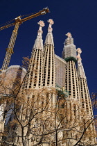 Spain, Catalonia, Barcelona, Basilica i Temple Expiatori de la Sagrada Familia, Generally known as Sagrada Familia, General view of the Passion Facade with crane hanging above.