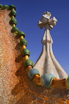 Spain, Catalunya, Barcelona, Antoni Gaudi's Casa Batllo building, dragon's back feature on the roof terrace with the four armed cross also inclluded.