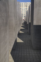 Germany, Berlin, A tourist walking through The Memorial to the Murdered Jews of Europe more commonly known as the Holocaust Memorial.