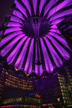 Germany, Berlin, Potzdamer Platz, Sony Centre with glass canopied roof over central plaza at night.