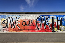 Germany, Berlin, The East Side Gallery, a 1.3  km long section of the Berlin Wall, Mural known as Save our Earth by Artist Indiano.