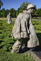 USA, Washington DC, National Mall, Korean War Veterans Memorial, Statues of soldiers on patrol in combat gear among juniper bushes.