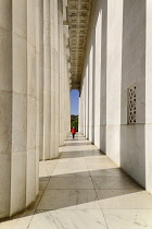 USA, Washington DC, National Mall, Lincoln Memorial, A tourist strolling among the Doric columns of the peristyle surrounding the memorial.