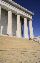 USA, Washington DC, National Mall, Lincoln Memorial, A tourist sitting among the Doric columns of the peristyle surrounding the memorial.