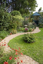 English cottage garden, winding shingle path leading to a gazebo between grass lawn and flowerbed of mixed plant varieties.