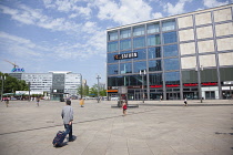Germany, Berlin, Mitte, Tourist crossing Alexanderplatz with luggage.