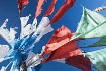 China, Tibet, Blessing colorful Tibetan prayer flags waves under the blue sky.