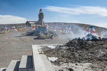 China, Tibet, An altar with smoking gifts and colorful prayer flags at the Tibetan sacred religious place.