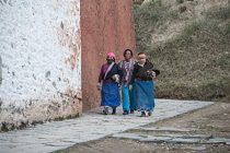 China, Tibet, Women praying whilst moving around a temple at Labrang Monastery.